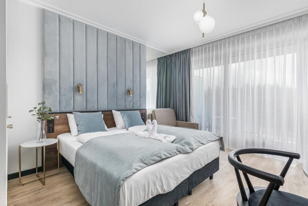 sypialnia z dużym łóżkiem i krzesłem w obiekcie Apart Park - Stylowe Studio 3 min od PLAŻY by Noclegi Renters w Świnoujściu