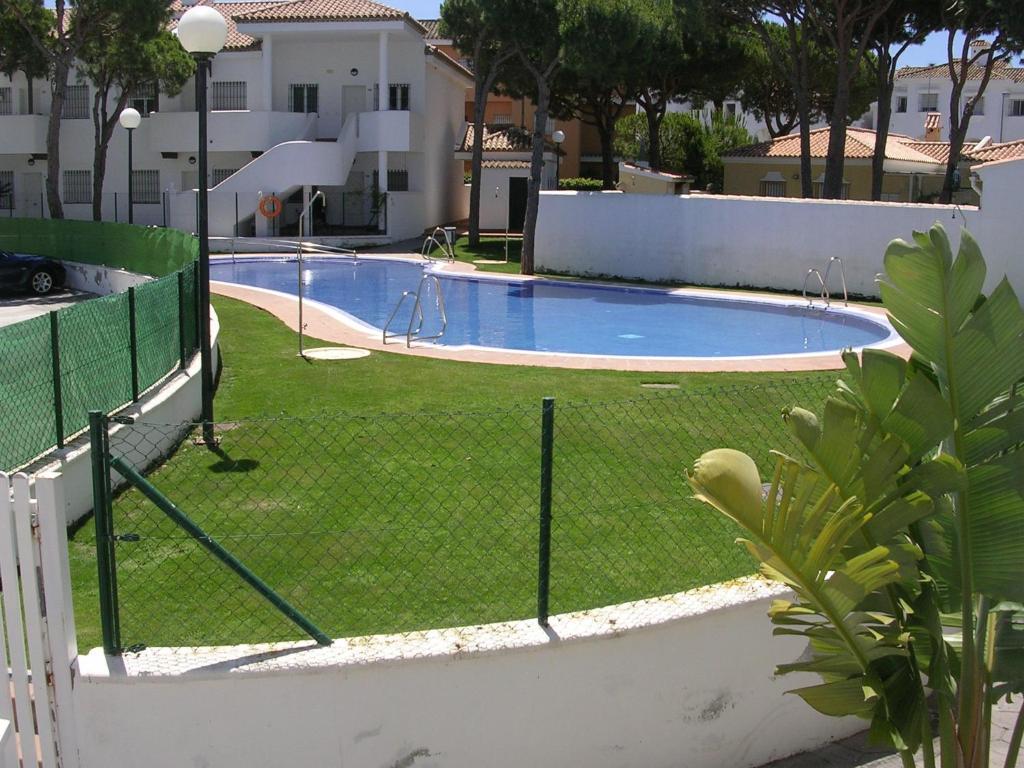 una valla alrededor de una piscina en un patio en Chiclana Costa, en Chiclana de la Frontera