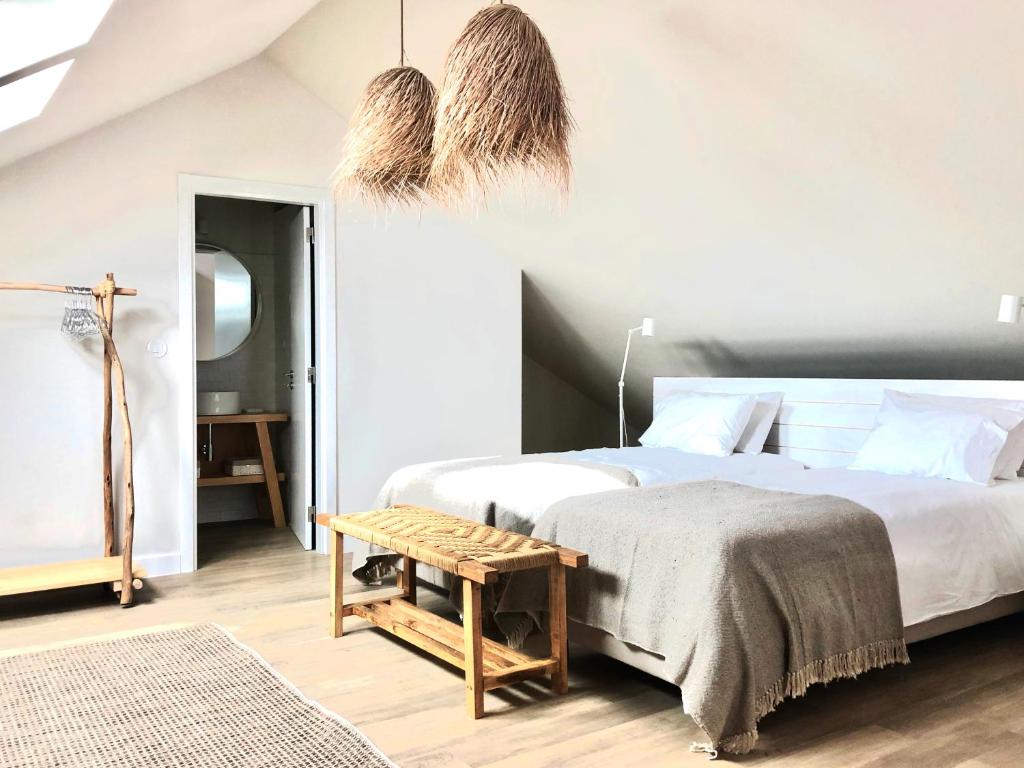 una camera con un letto e una panca accanto ad essa di Charming Design House in Montijo, Casa 41 a Montijo