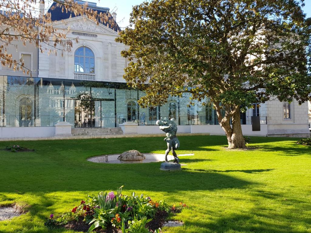 una estatua en un parque frente a un edificio en La maison Virginie log 1 à 2 pers charmant hyper centre parking linge wifi proximité lac canal piscine en Montargis