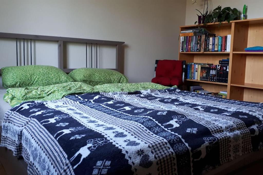 Una cama con una manta azul y blanca. en Private room in our home with free VVO ticket & cats, en Pirna