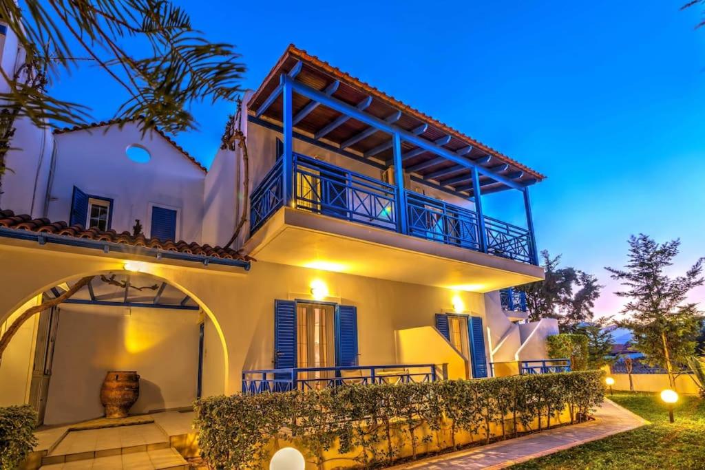 a large white house with a balcony at night at Cretan Dawn Apart, Value Option in Ammoudara in Ayía Marína