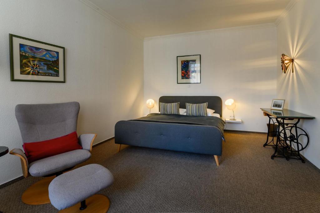 フーズムにあるstadthaus husumのベッドルーム1室(ベッド1台、椅子付)