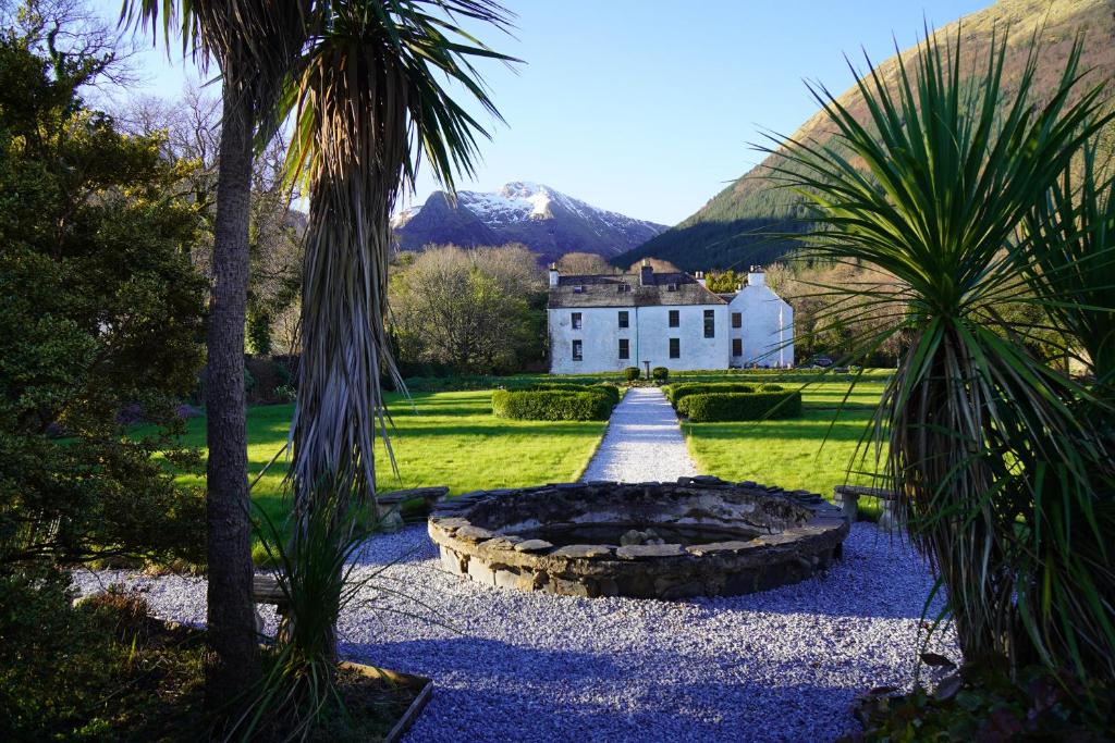 a house with a palm tree and a fire pit at Ballachulish House Apartment in Ballachulish