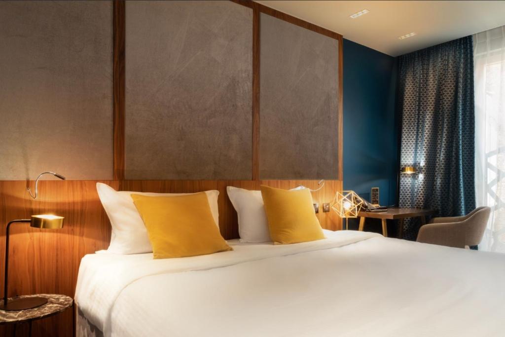 - une chambre avec un grand lit et des oreillers jaunes dans l'établissement Harmon House, à Bruxelles