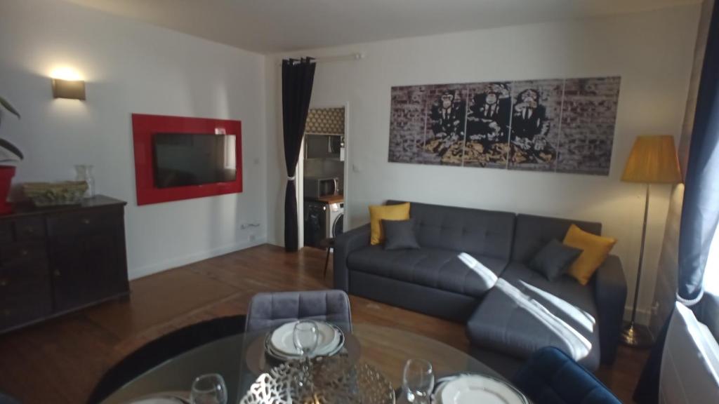 a living room with a couch and a table at Coeur de ville, calme, spacieux,Parking et wifi ! in Chartres