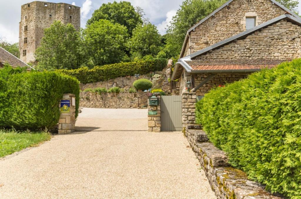 a driveway leading to a house with a castle in the background at La Maisonnette in Chaudenay-le-Château