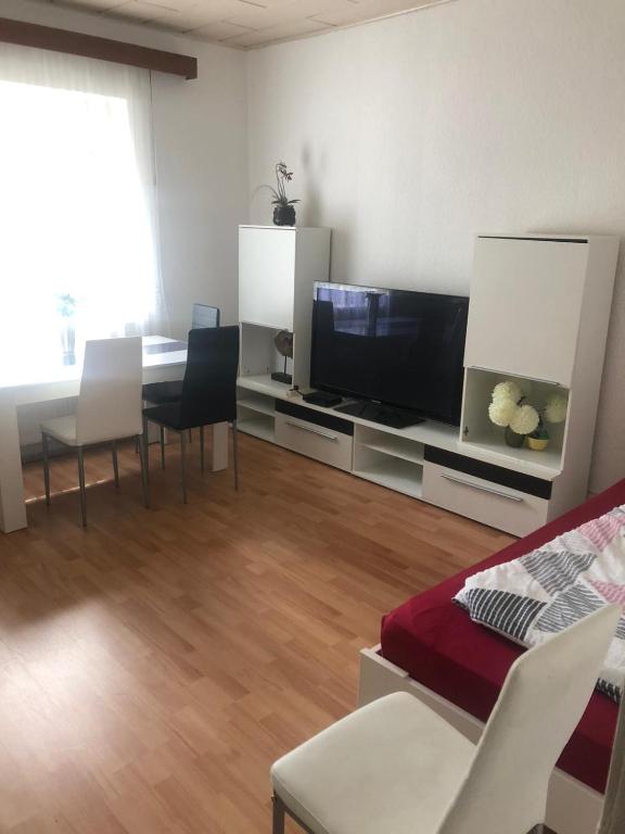 a living room with a tv and a table and chairs at Schöner Wohnen in Senzig bei Berlin 2 in Senzig