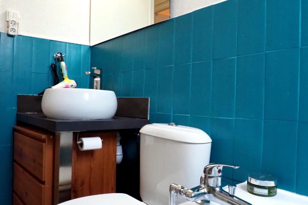 a bathroom with a toilet and a sink and blue tiles at Apartment Historical City Center in Annecy