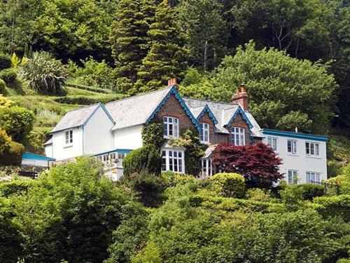 a house on top of a hill with trees at Pine Lodge in Lynton