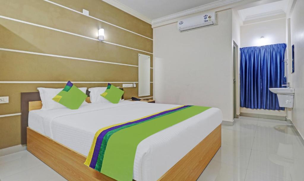 a bedroom with a bed and a sink in it at Treebo Trend Thoduvas Star Plaza Cochin Airport in Nedumbassery