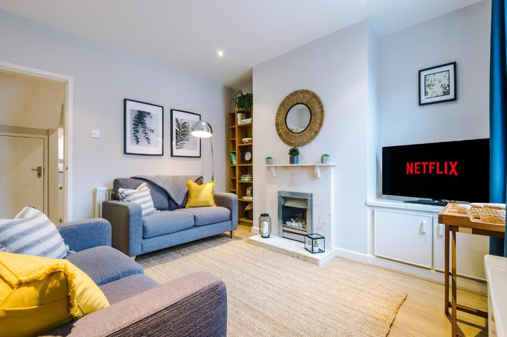 a living room with a blue couch and a fireplace at Quaint 2 Bedroom Chester City Cottage in Chester