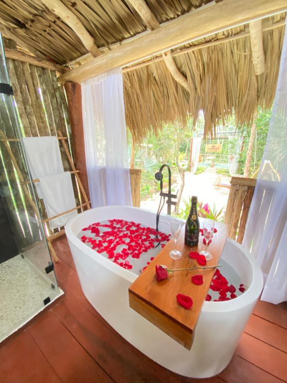a bath tub filled with red roses in a room at Nuscaa Boutique Tree House & Spa in Puerto Morelos