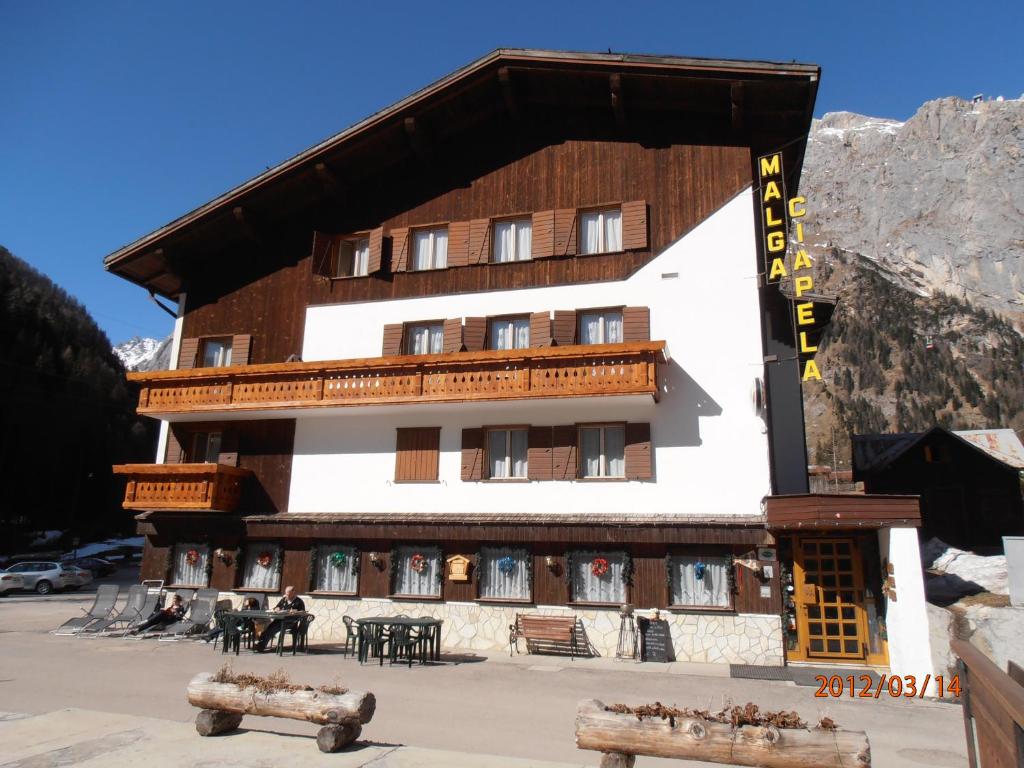 un gran edificio con mesas delante en Albergo Malga Ciapela, en Rocca Pietore