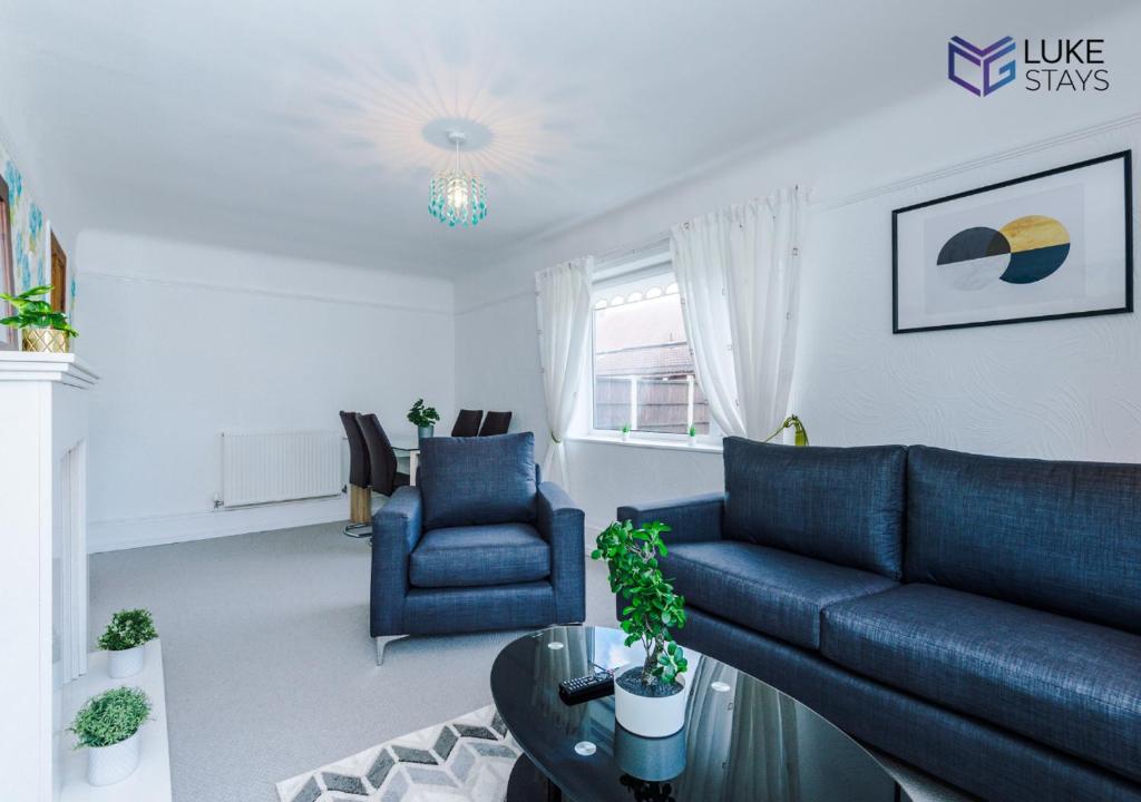 uma sala de estar com um sofá azul e uma mesa em Luke Stays - John Hunter Way em Sefton
