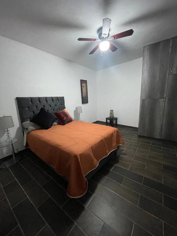 1 dormitorio con 1 cama y ventilador de techo en Lovely and warming 3 bed en Morelia