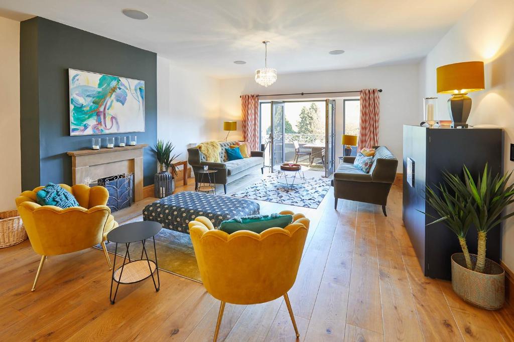 a living room with yellow chairs and a fireplace at Host & Stay - The Lakehouse in Whitby
