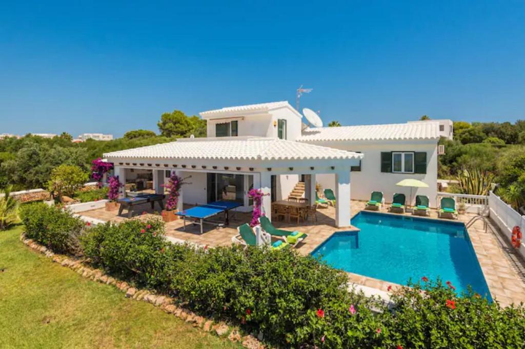 a villa with a swimming pool and a house at Villa Marisol in Sant Lluis