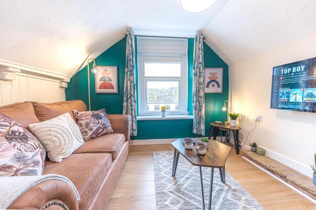 a living room with a brown couch and a window at Queen Street Apartments in Whitehaven