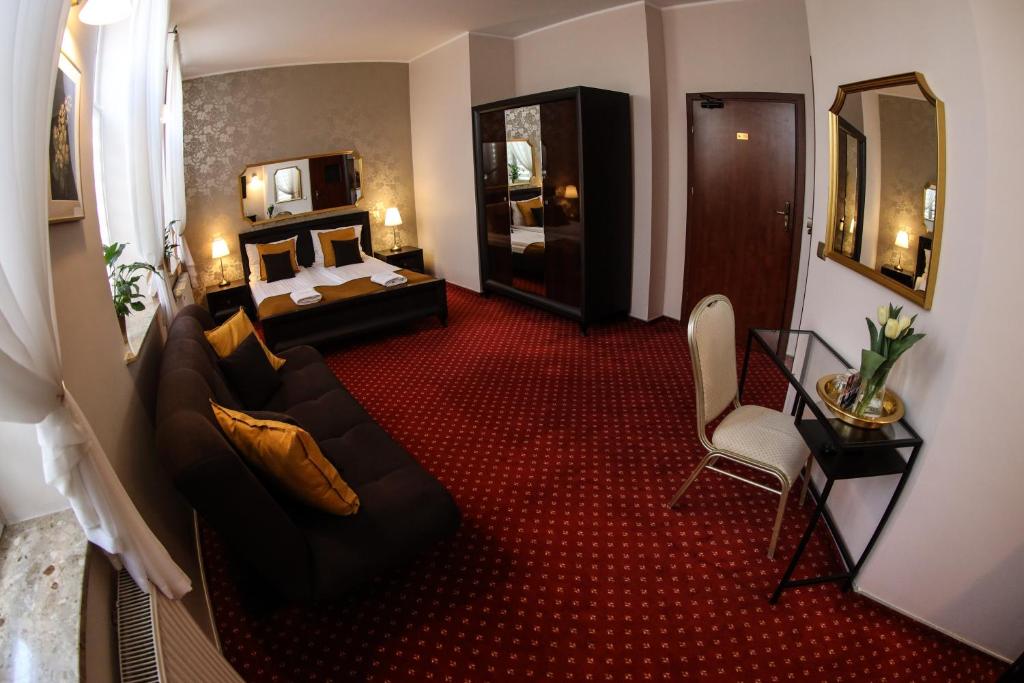 a hotel room with a couch and a bed at Valdi Classic in Zabrze