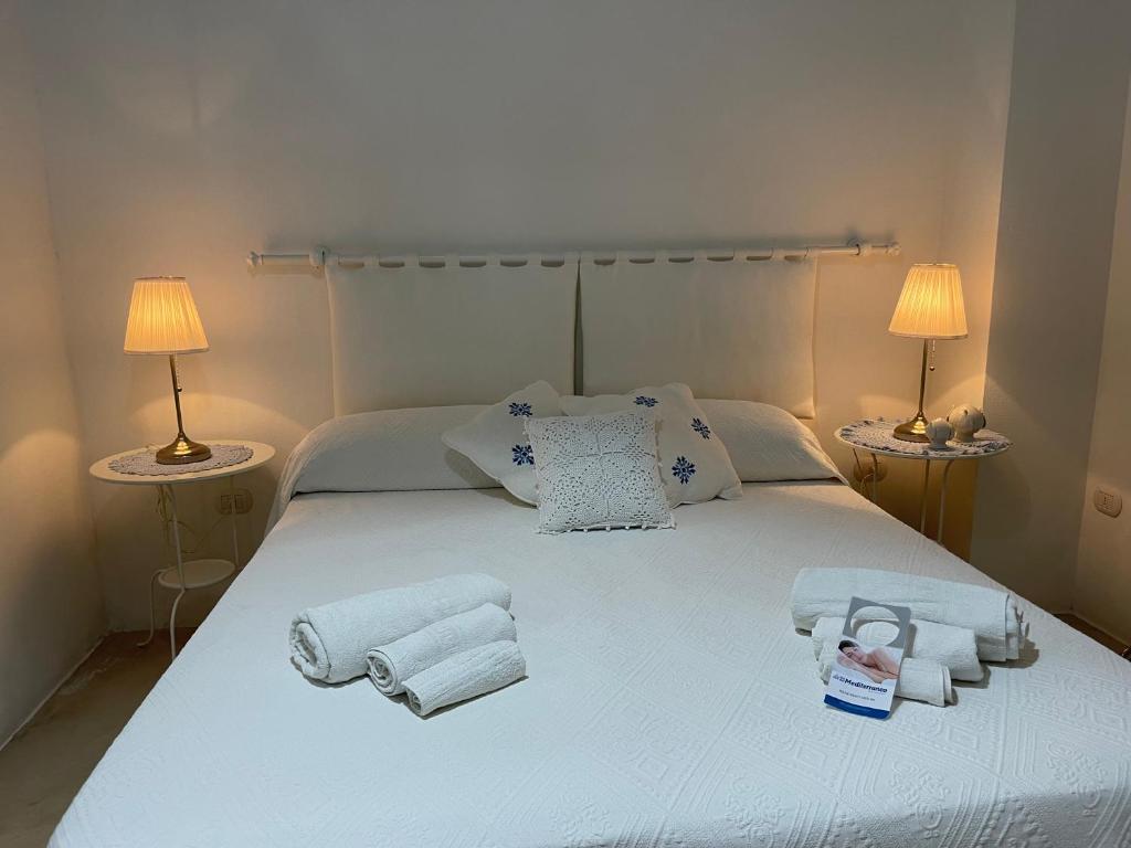 ein Schlafzimmer mit einem weißen Bett und Handtüchern darauf in der Unterkunft B&B Vie del Mediterraneo in Porto Cesareo