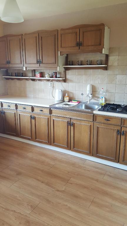 een keuken met houten kasten en een spoelbak bij Pod srebrną różą in Chęciny