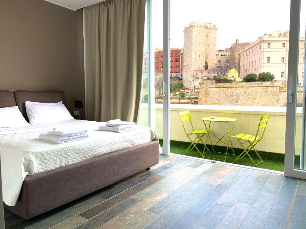 a bedroom with a bed and a table and chairs at Vista Suites - Piazza Yenne in Cagliari