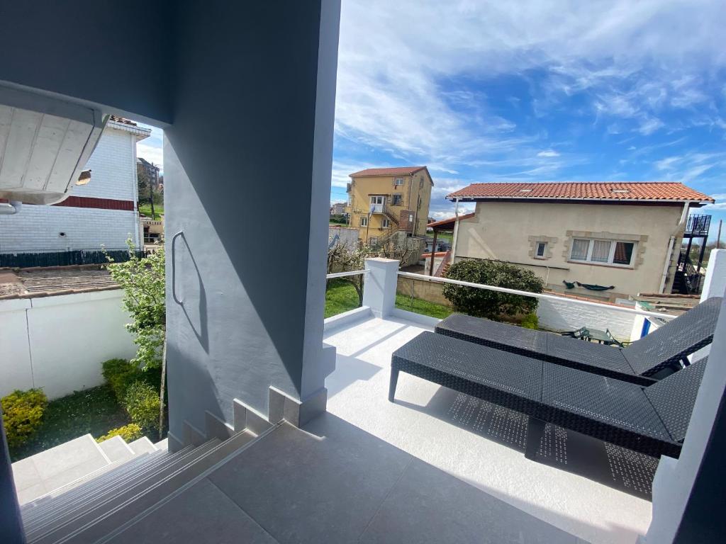 a balcony with a bench and a view of a house at Design Club Santander in Santander