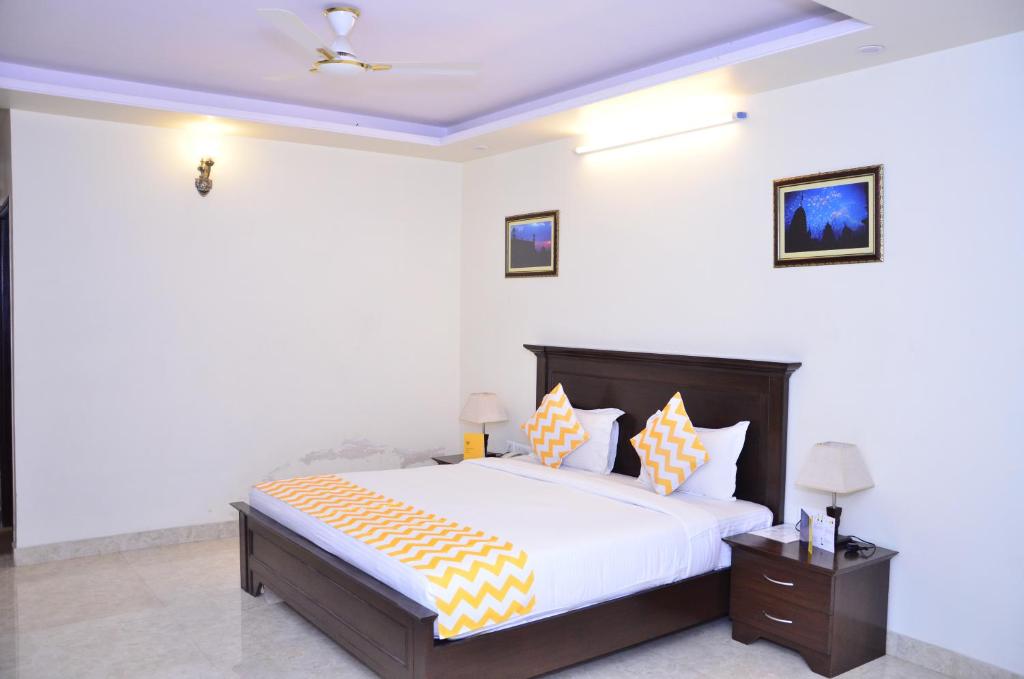 a bedroom with a large bed with orange and yellow pillows at Raj Regency in Jaipur