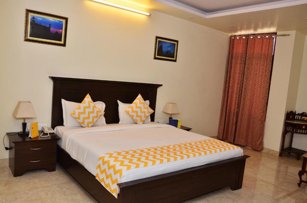 a bedroom with a large bed with orange and white pillows at Raj Regency in Jaipur