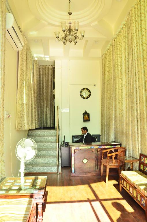 a man sitting at a desk in a living room at Raj Regency in Jaipur
