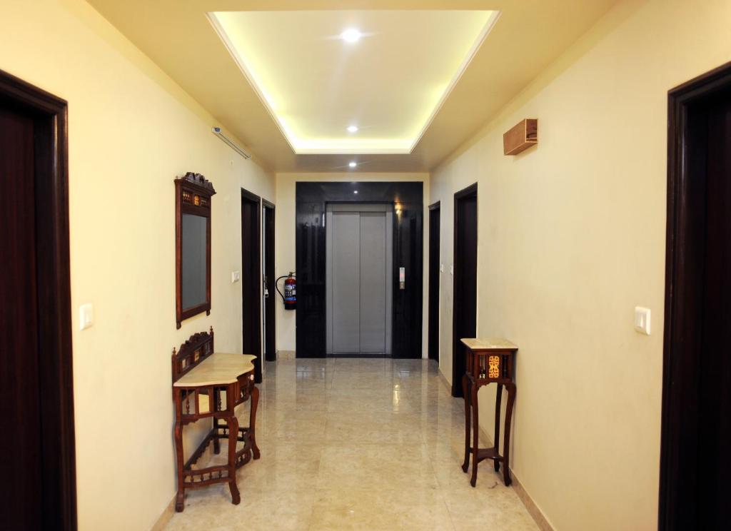 a hallway with two chairs and a hallway with a door at Raj Regency in Jaipur