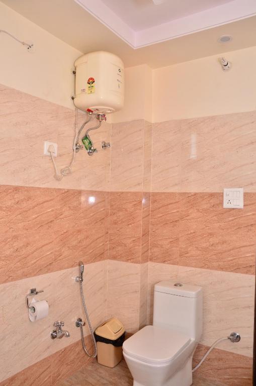 a bathroom with a toilet and a toilet paper dispenser at Raj Regency in Jaipur
