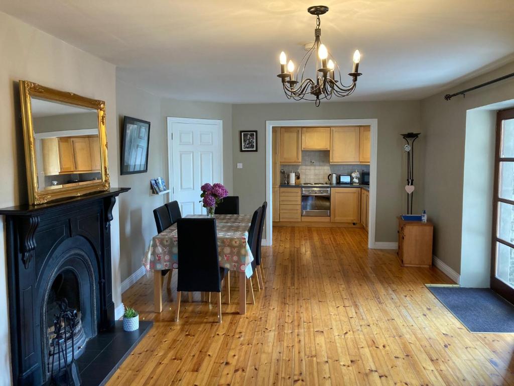 a living room with a dining room table and a fireplace at Beautiful & Quiet Countryside Setting in Kinsale in Cork