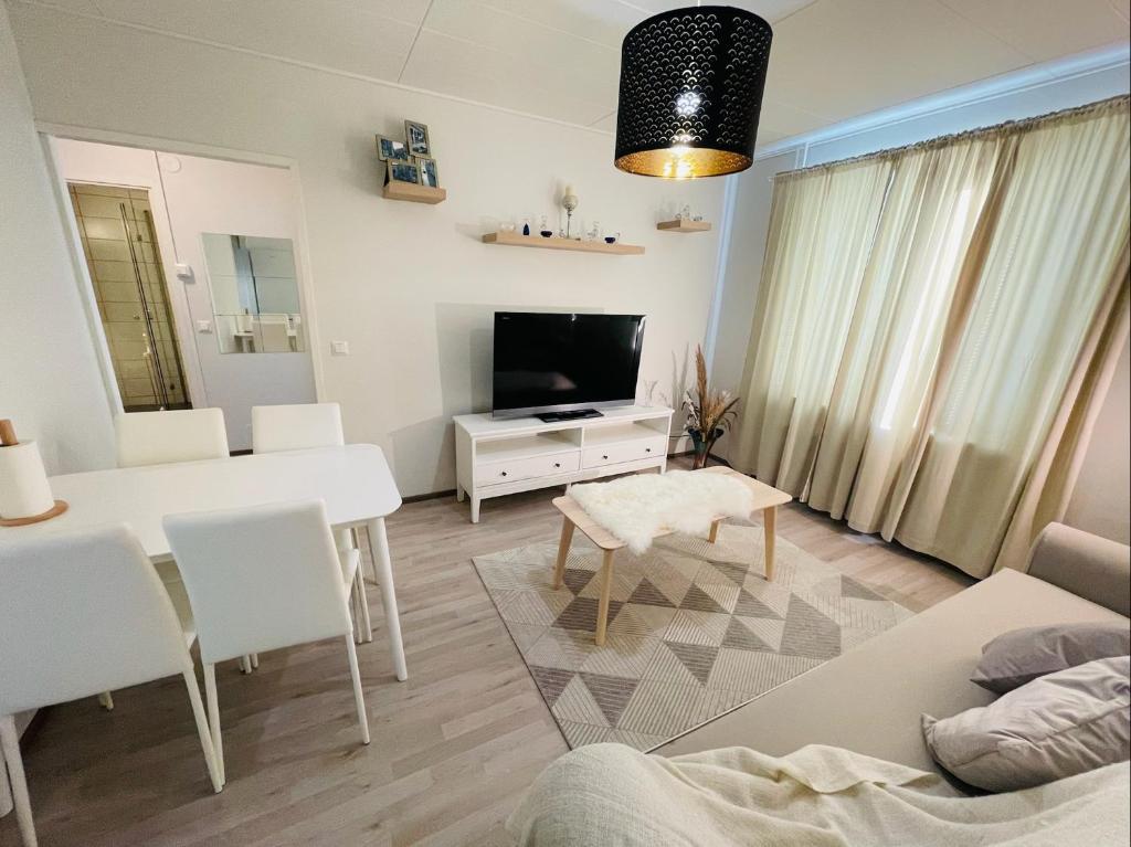 sala de estar con mesa blanca y TV en Ilona Apartments - "The City Condo" en Kotka