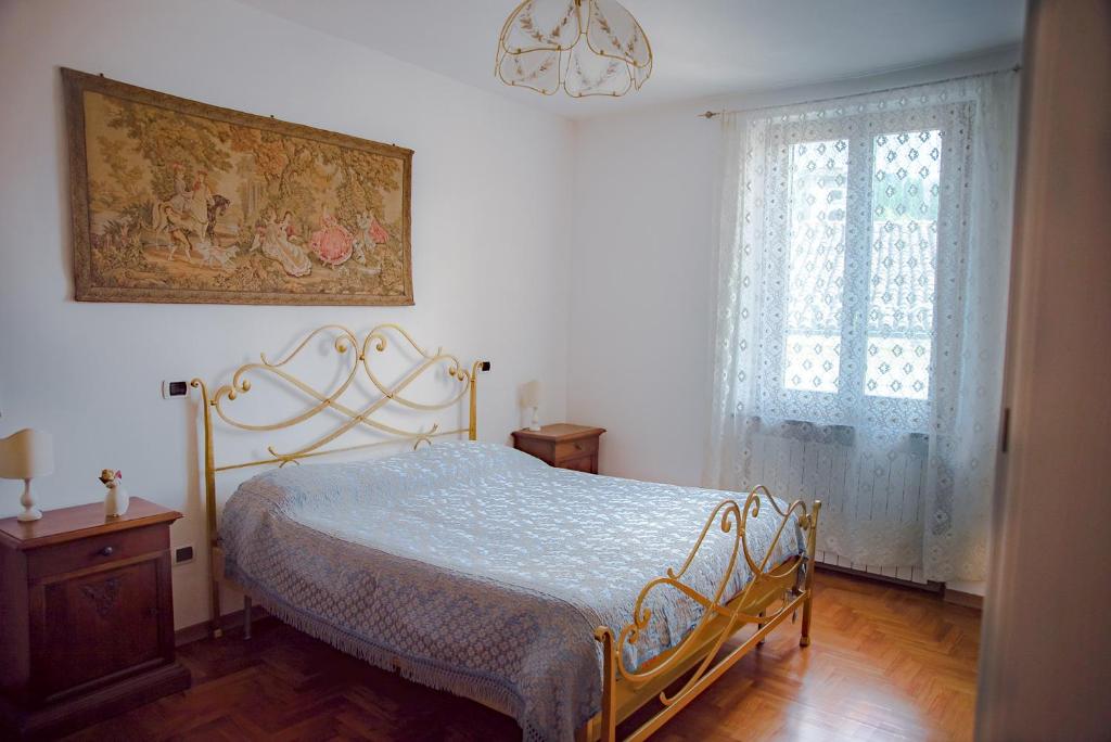 sypialnia z łóżkiem i obrazem na ścianie w obiekcie BENVENUTI A CASA PAOLA , WELCOME IN GARFAGNANA! w mieście Castelnuovo di Garfagnana