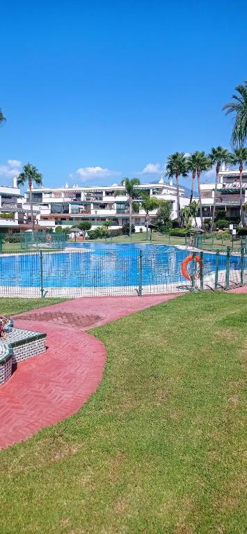 una piscina in un parco con parco giochi di Cozy Room with sunny terrace a Marbella