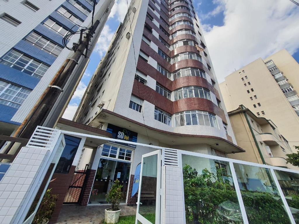 a tall building with glass doors in front of it at Apto frente à praia, aconchegante, vista lateral pro mar! in São Vicente