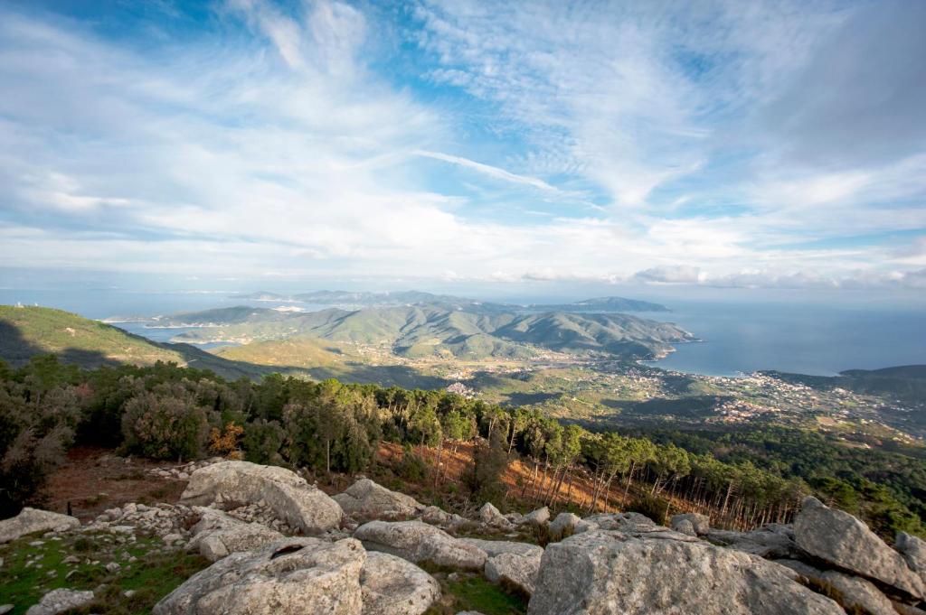 uma vista para uma cidade e para o oceano a partir de uma montanha em Sulla Valle di Seccheto em Seccheto