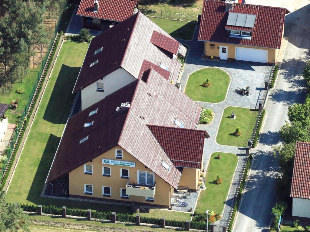 Pension + Apartments Tor zum Spreewald في لوبين: اطلالة جوية على بيت ذو سطوح حمراء