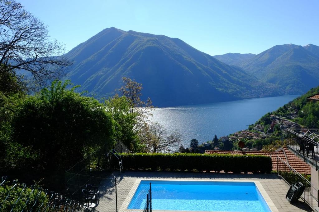 a swimming pool with a view of a lake and mountains at Villa Rosa in Argegno