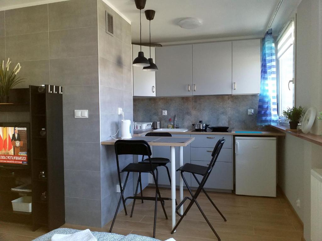 uma cozinha com uma mesa e cadeiras em Apartament Centrum 32m2 Kłodzko - Przyjaciół Ziemi Kłodzkiej em Kłodzko