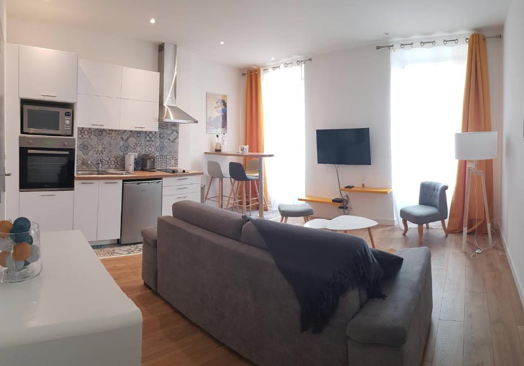 Una sala de estar con un sofá y una cocina. en Cosystudio centre Ajaccio, en Ajaccio