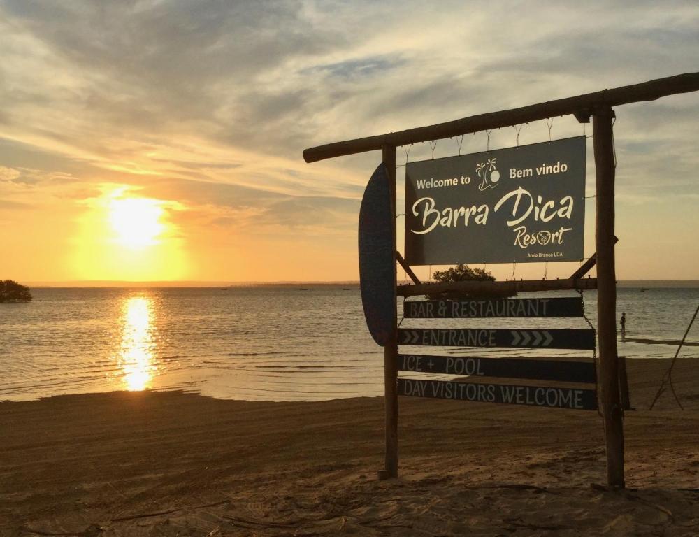 znak na plaży z zachodem słońca w tle w obiekcie Barra Dica Resort w mieście Cabo Nhamua