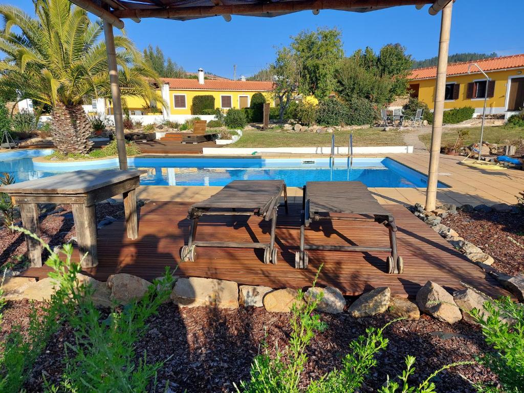a deck with a table and chairs next to a pool at Quinta Cunte - Casa Sobreiro in São Luis