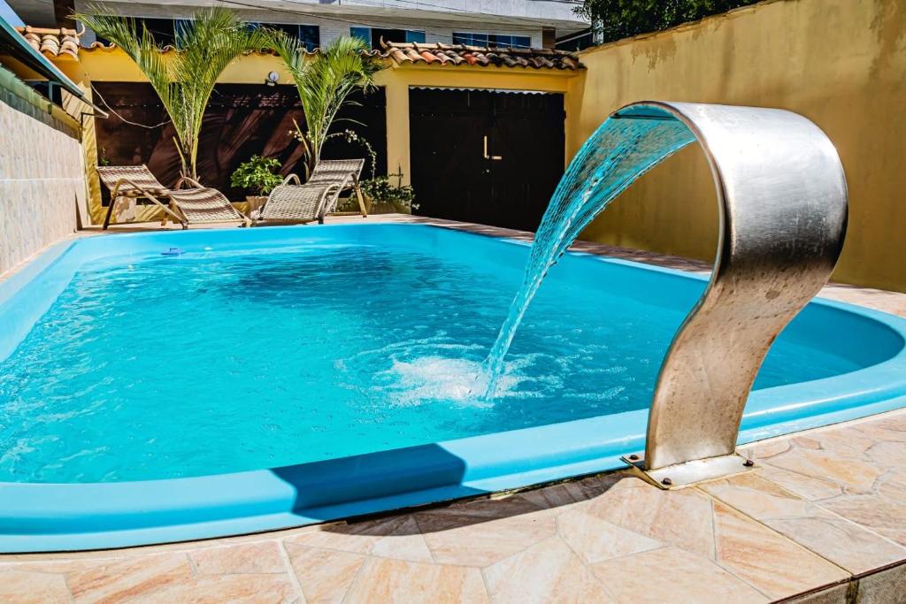 a pool with a water fountain in a yard at Casa De Praia Sol e Mar in Cabo Frio