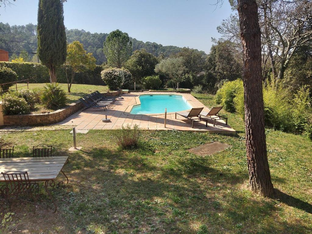 a swimming pool in a yard with chairs around it at Comorebi Provence in Entrecasteaux