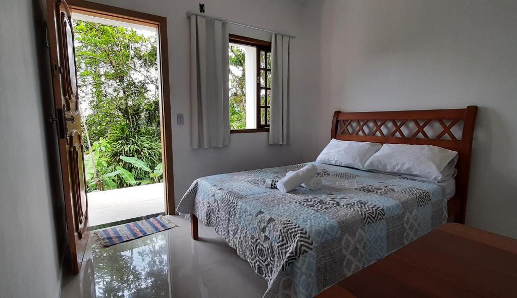 a bedroom with a bed and a large window at Ilha Suites - Vila do Abraão in Abraão