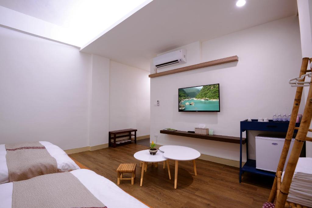 a bedroom with a bed and a table and a tv at Mixa Hostel in Hualien City