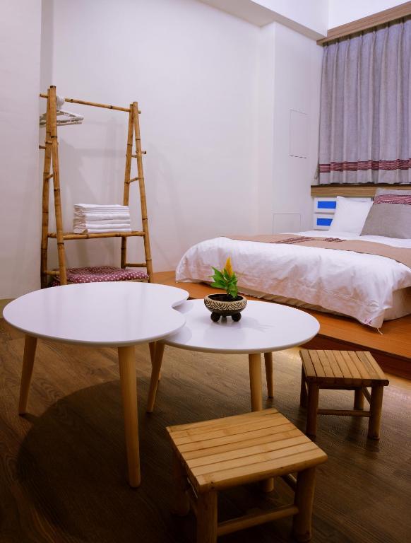two tables in a room with a bed at Mixa Hostel in Hualien City